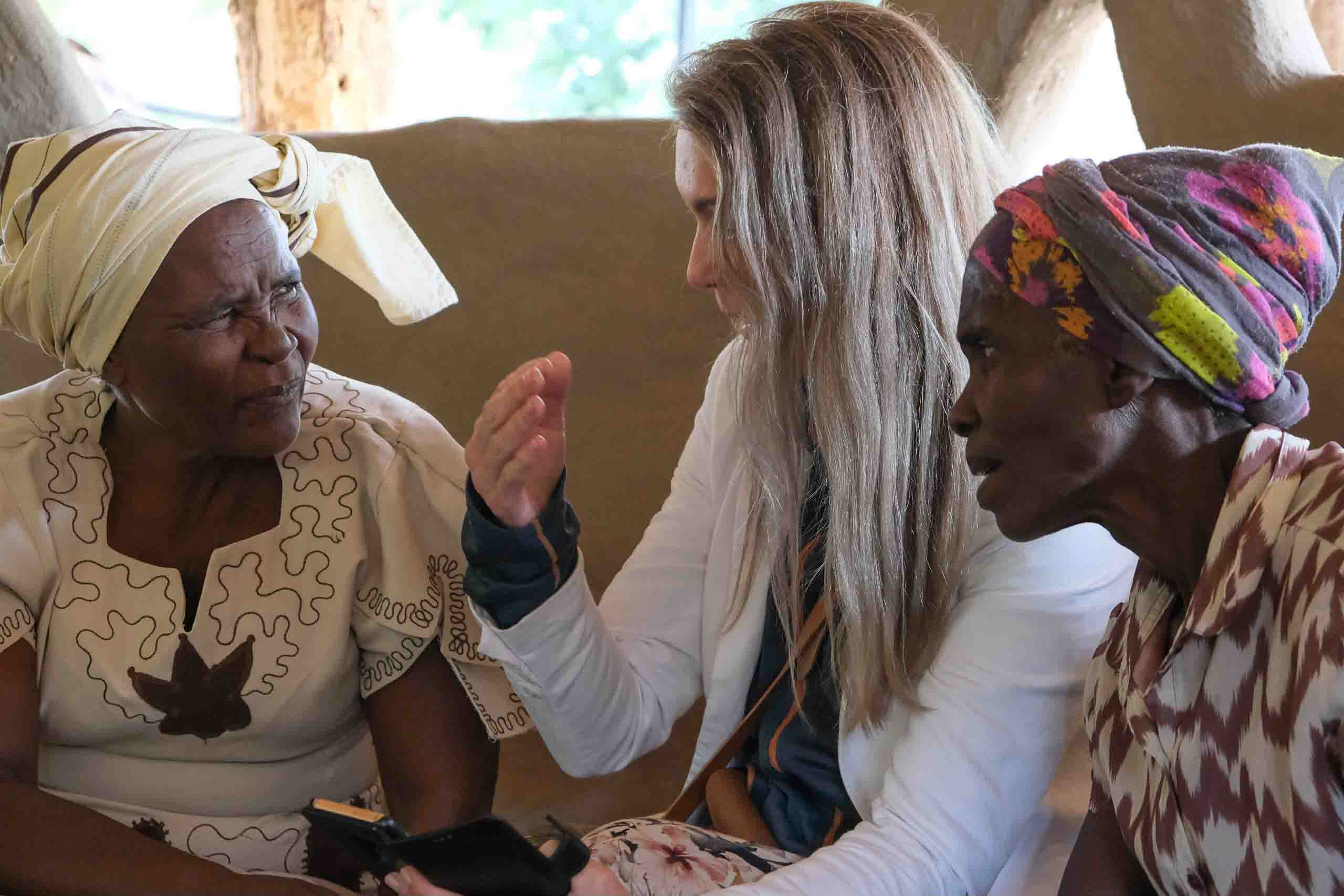 Hildegunn i samtale med to kvinner i en landsby i Zimbabwe