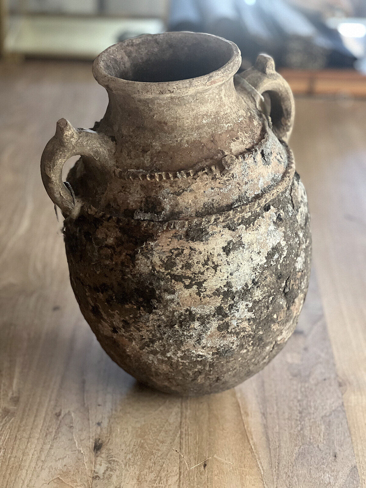 Den antikke Tamegroute-krukka på gulvet i galleriet, ca. 38 cm høy, uglasert terrakotta med sot og kalkbelegg