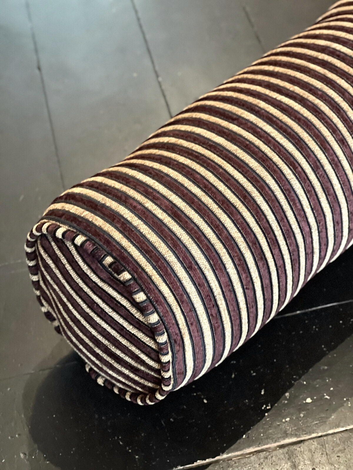 Nærbilde av vevet og endelokket på pølleputa, aubergine og gyllenbeige med tynn sort stripe