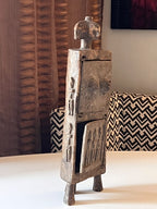 Medisinskap fra Dogon-folket i Mali sett fra siden, med utskårne figurer på sidepanelet