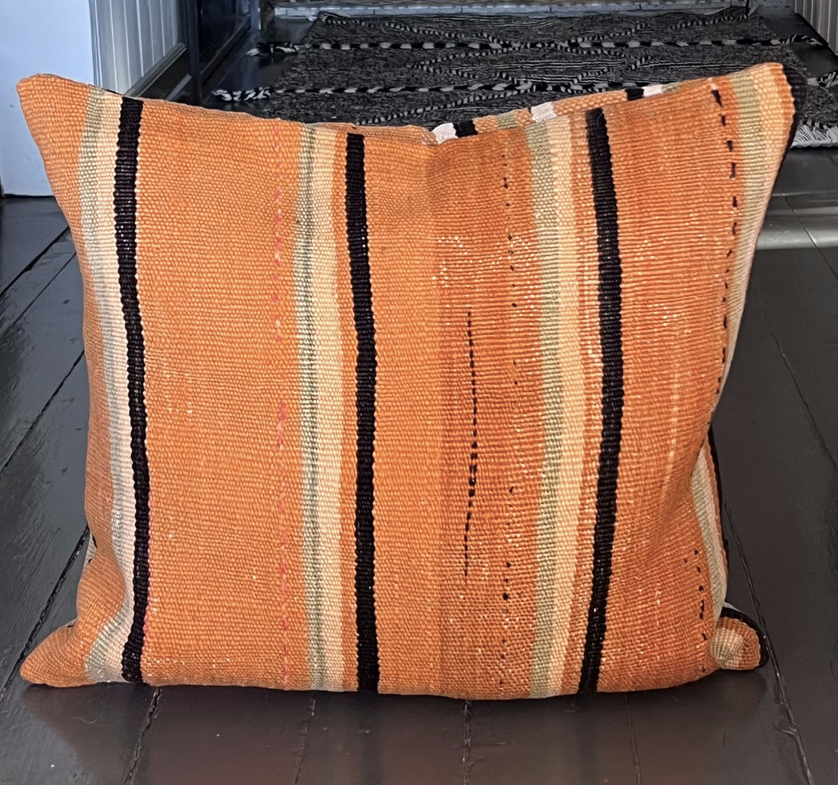 Kelimpute i varm orange terrakotta med striper i sort, beige og lysegrønt, ca. 50x50 cm, ekte foto