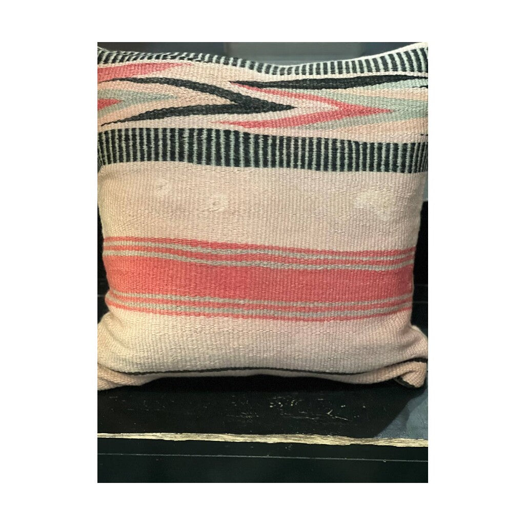 Nærbilde av kelimpute fra Marokko ca. 50x50 cm i rosa med svarte piler, med små vintage merker på den ene siden