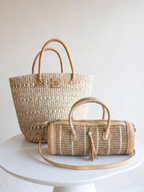 Sylinderveske i beige sisal med striper sammen med sisalkurv